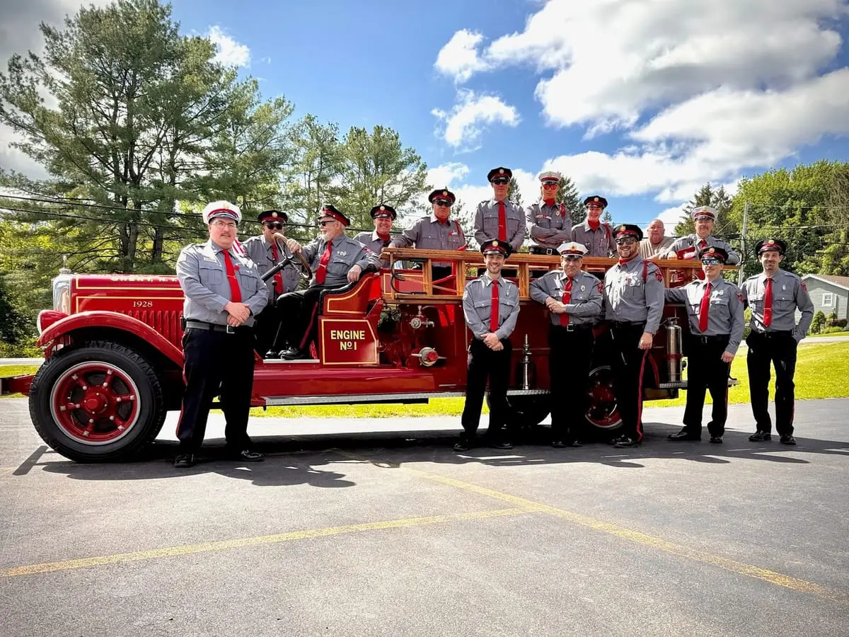 Dress Crew Aboard the 1928 LaFrance — Ghent officers and members in Class A dress uniform aboard Engine No. 1 before a county parade.