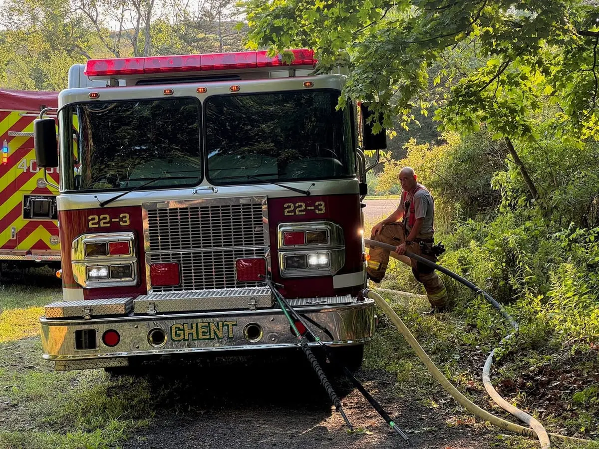 Rescue 22-43 on Scene — Pump operator working the panel on Rescue-Pumper 22-43 during a daytime response.