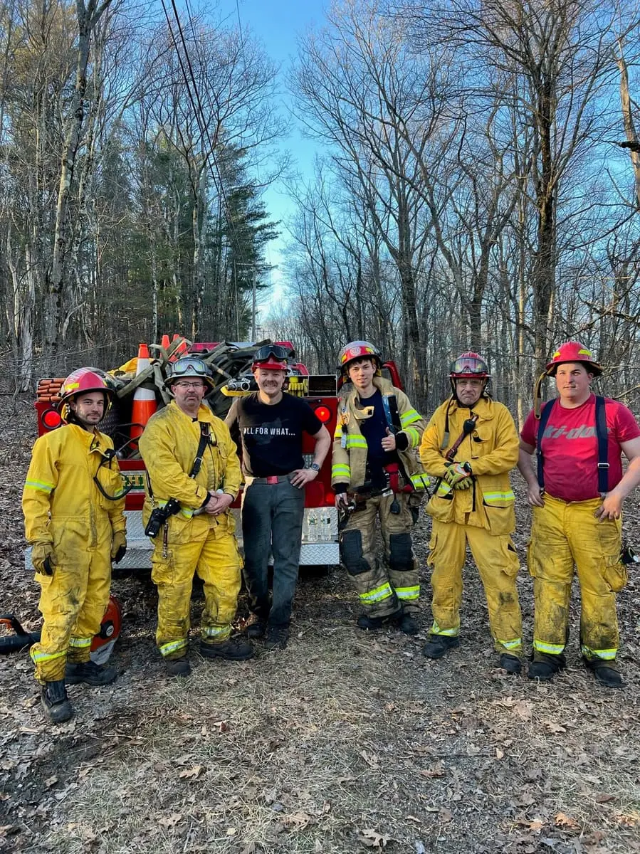 Wildland Forestry Crew — Ghent firefighters with rakes, brooms, and Indian cans after knocking down a field fire.