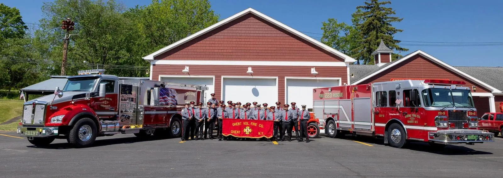 Full membership of Ghent Volunteer Fire Company No. 1 in Class A dress uniforms flanked by the 1928 American LaFrance and frontline engines