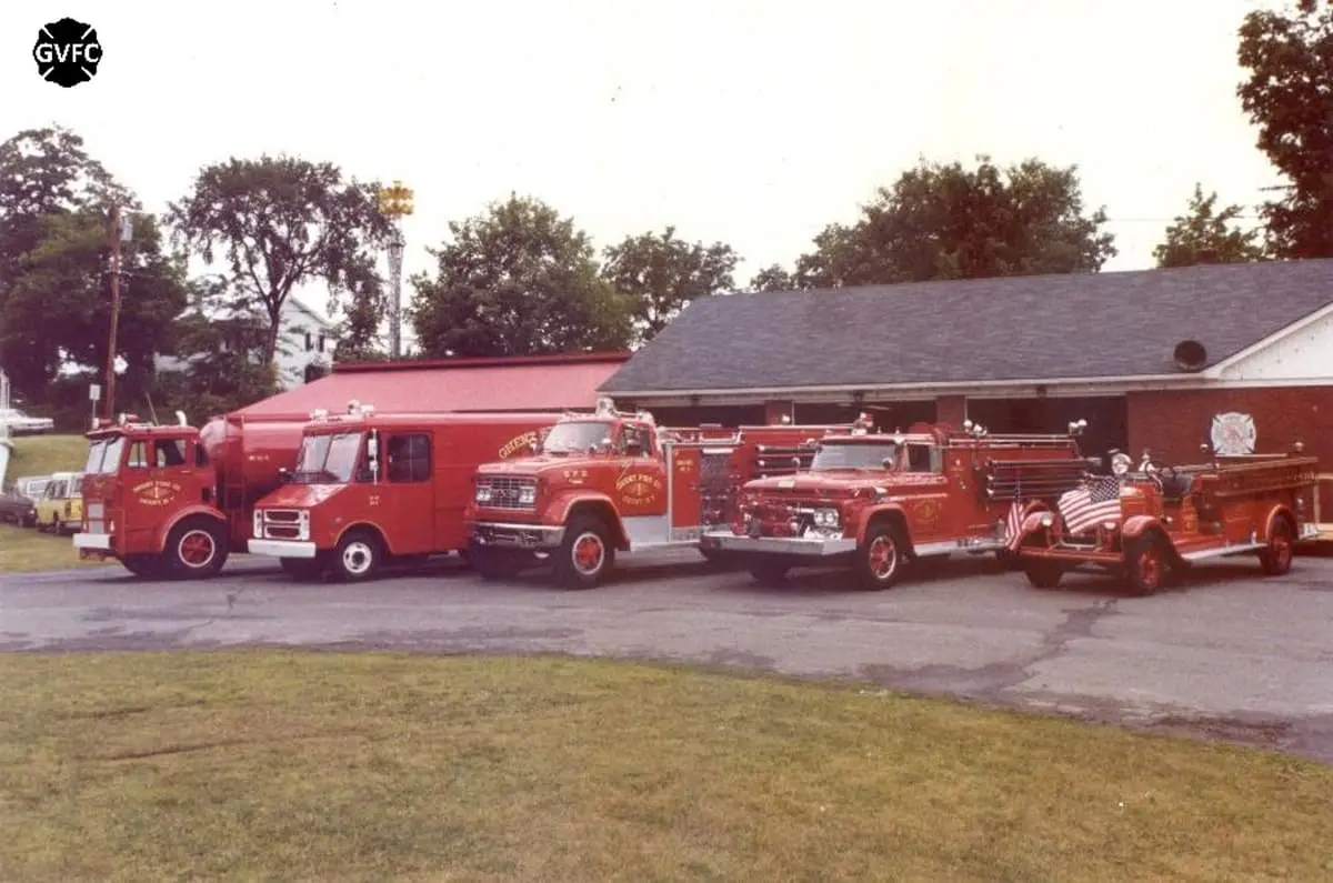 Ghent Apparatus Lineup Through the Eras — Archival lineup of vintage Ghent engines and tankers outside the Route 66 firehouse.