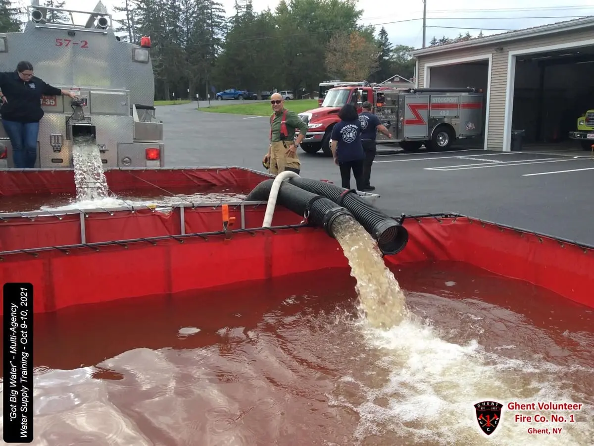 Dual Drop-Tank Water Shuttle — Chained portable ponds connected by high-volume low-level siphons during multi-company water supply drills.